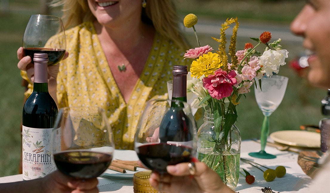 Friends around a table enjoying Cassia Seraphim Social Beverage as a non alcoholic drink wine alternative